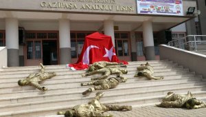 Bronz görünümünde asker kılığındaki öğrenciler, okul merdiveninde şehit düşmüş halde yattılar