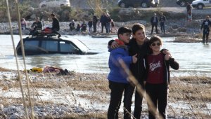 Kanalın ortasında mahsur kalan aracın önünde poz verdiler