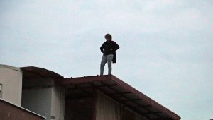 Hakkında arama kararı bulunan kadın, polisi görünce çatıya çıktı