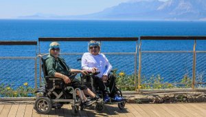 Akülü sandalyeleriyle sokağa çıkan çift, deniz hasretini giderdi