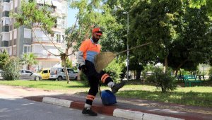 Süpürgesiyle dans ederek sokakları temizliyor