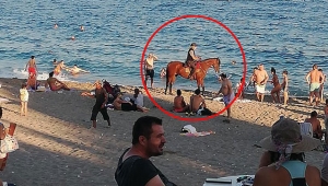 Kovboy şapkası takıp, atını denize sürdü