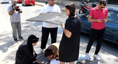 Yaralı motosikletliyi güneşten korudular
