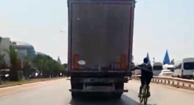 TIR'ın arkasına tutunan bisikletlinin tehlikeli yolculuğu