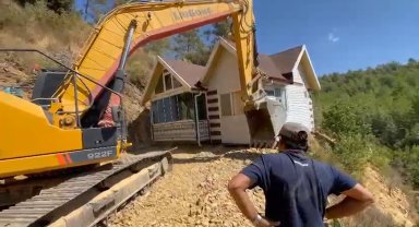 Yıkım kararı verilen konteyner evini iş makinesiyle karadan rayla yürütüp taşıdı